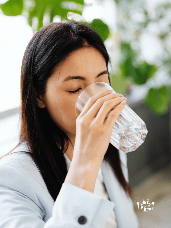 Femme sui boit un verre d'eau